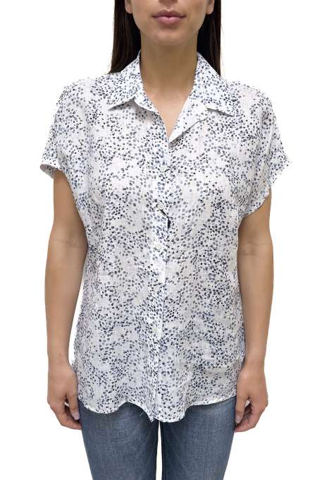 Woman wearing a white short-sleeve shirt with black floral pattern on a white background