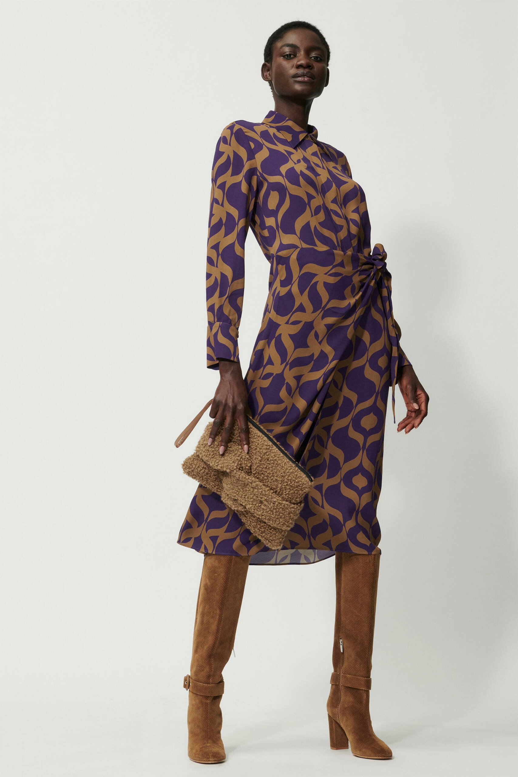Model wearing graphic tapestry print dress in purple and camel.